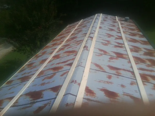Rusted metal roof panels with new wood purlins before replacement — Storm Damage Roof Repair in Attica by Roofing Brothers