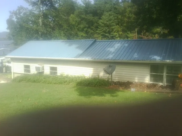 Blue metal roof running the length of a single story home in Attica